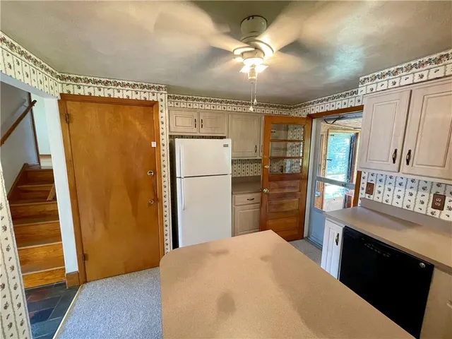 a kitchen with a refrigerator a stove and a wooden cabinets