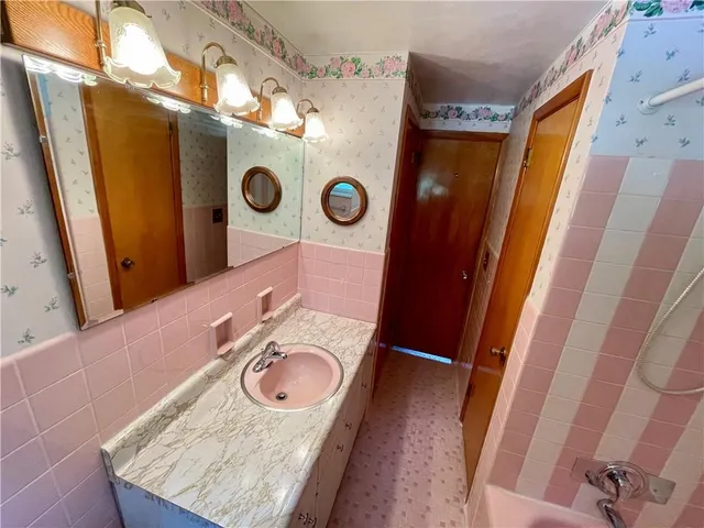 a bathroom with a sink a toilet and a mirror