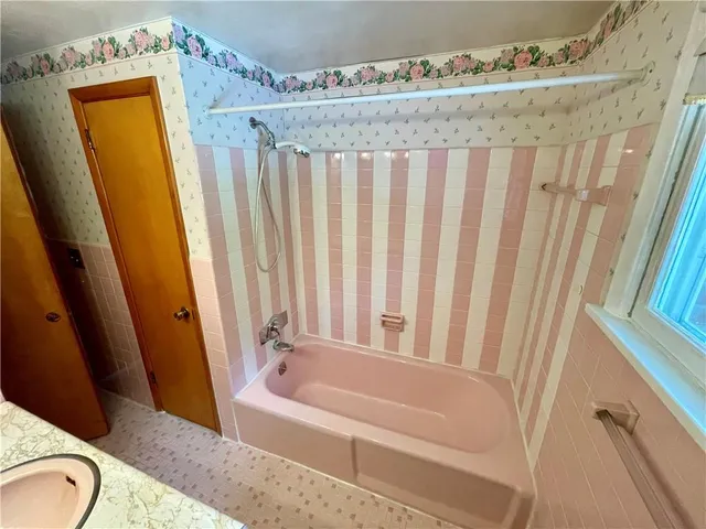 a bathroom with a granite countertop sink and a bathtub