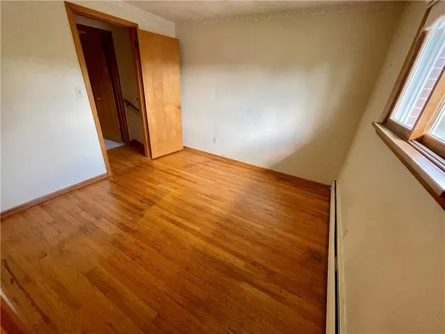 an empty room with wooden floor and closet