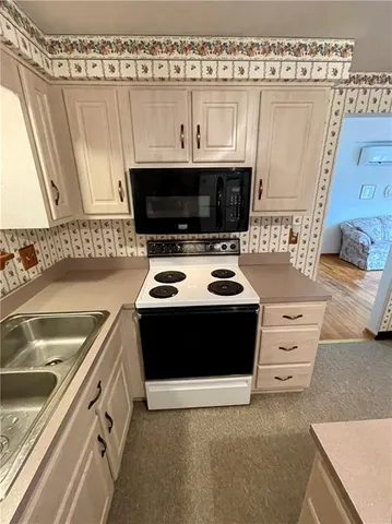 a kitchen with stainless steel appliances a stove a sink and a microwave