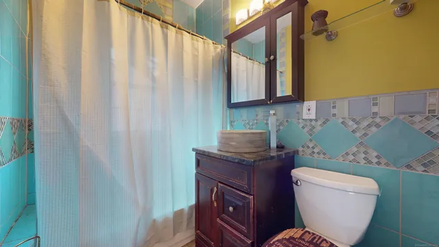 a bathroom with a toilet a sink and a mirror