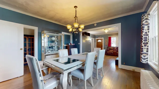 a dining room with furniture wooden floor and a chandelier