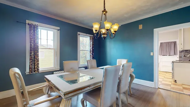 a view of a dining room with furniture a chandelier and wooden floor