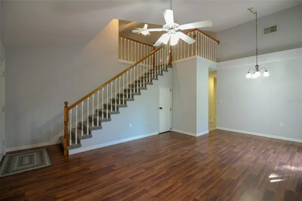 a view of a hallway with wooden floor and staircase