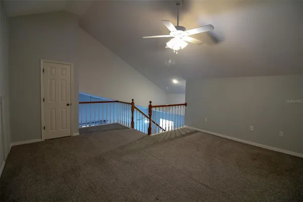 a view of an empty room with a chandelier fan