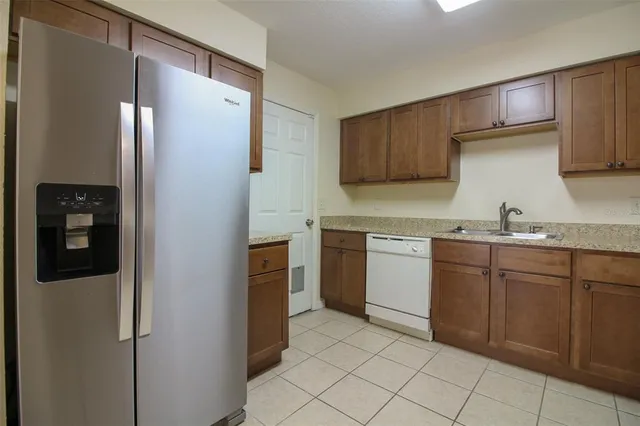 a kitchen with a refrigerator sink and cabinets