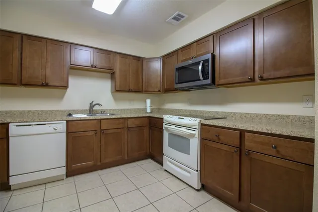 a kitchen with granite countertop cabinets stainless steel appliances and a sink