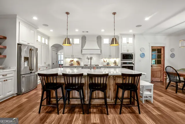 a dining room filled chandelier and wooden floor