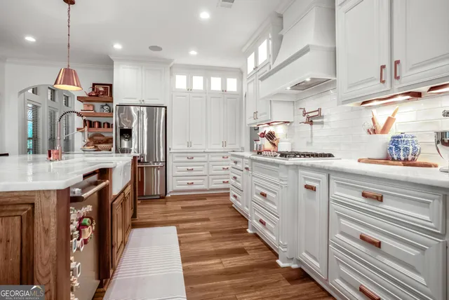a kitchen with stainless steel appliances granite countertop a refrigerator and a sink