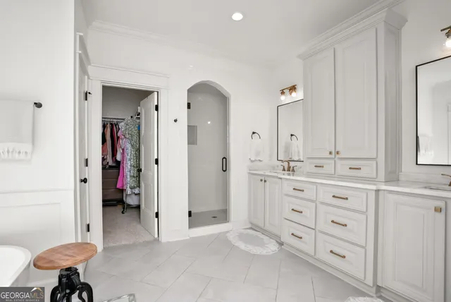 a spacious bathroom with a double vanity sink a mirror and a shower