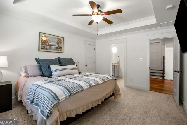 a spacious bedroom with a bed and a ceiling fan