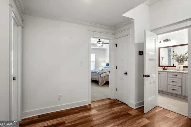 a view of a hallway with bathroom and wooden floor