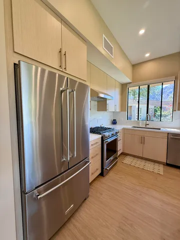 a large kitchen with a refrigerator a sink and a stove top oven