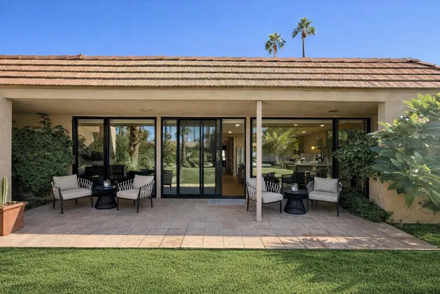 a view of a building with sitting area and garden