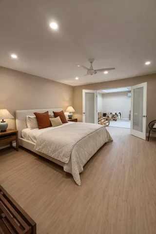 a spacious bedroom with a bed and a view of kitchen