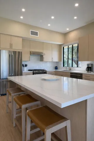 a kitchen with granite countertop a stove a sink and a refrigerator