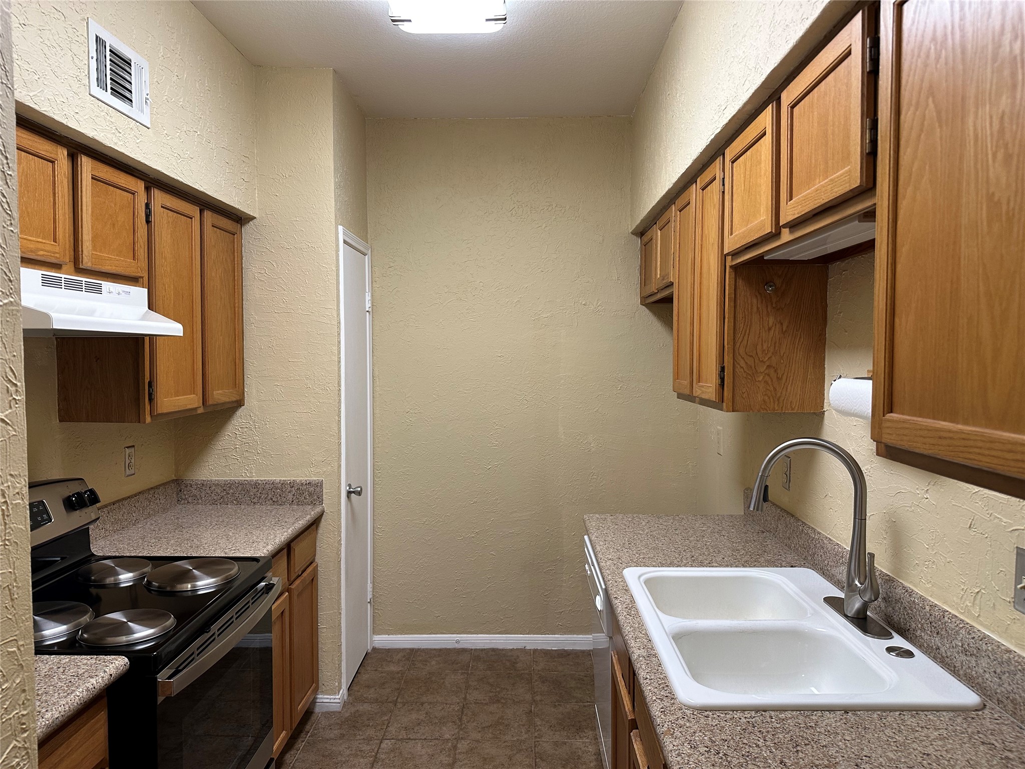 3800 Tanglewilde Street, Unit 504 Houston, TX 77063 - Photo 15 of 20 a kitchen with stainless steel appliances granite countertop a sink stove and cabinets