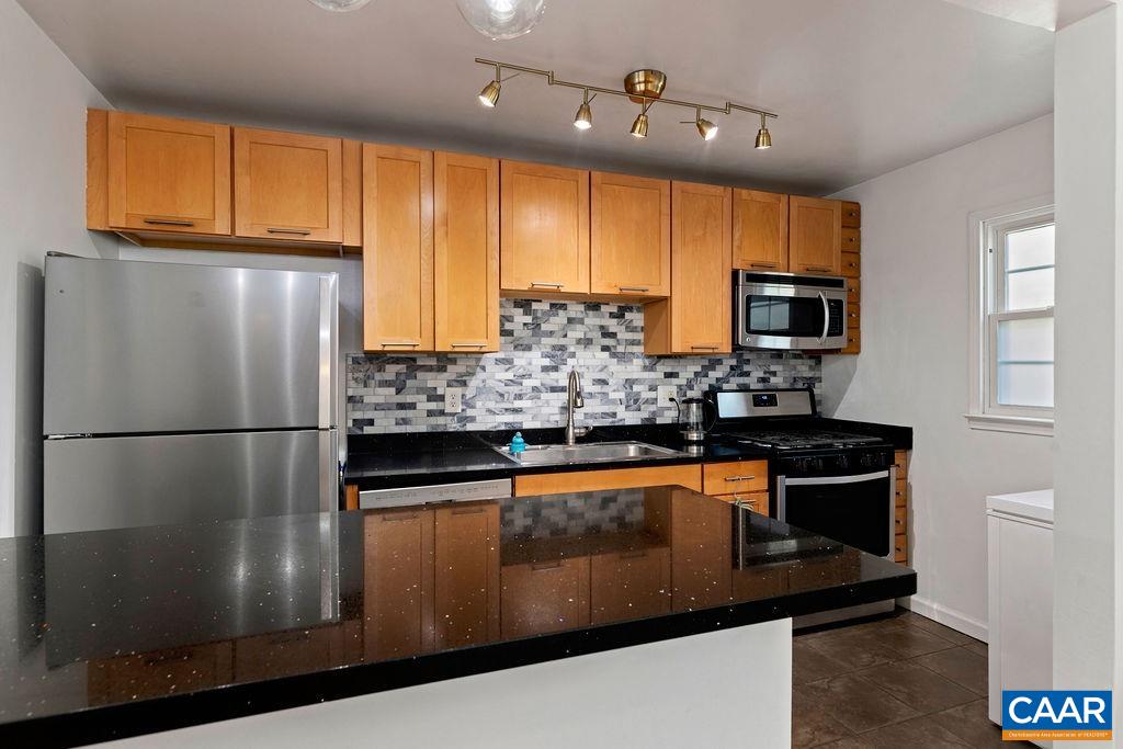 114 Hessian Hills Ridge, Unit 1 Charlottesville, VA 22901 - Photo 7 of 20 a kitchen with stainless steel appliances granite countertop a refrigerator a stove a sink a microwave and wooden cabinets