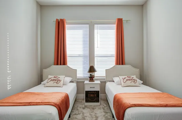 a bedroom with two beds and a window