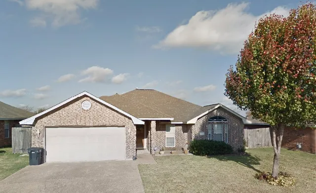 a view of a house with a yard and large tree