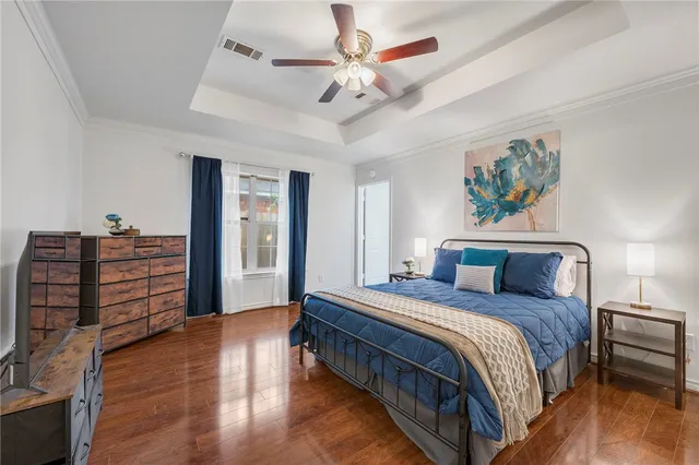 a bedroom with a bed chandelier and a window