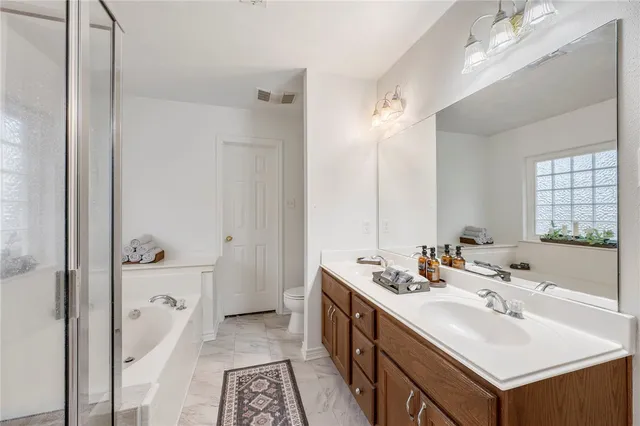 a en suite bathroom with a double vanity sink a mirror and a bathtub