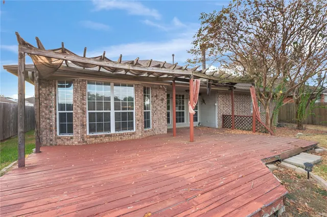 a view of a house with a wooden deck and a backyard