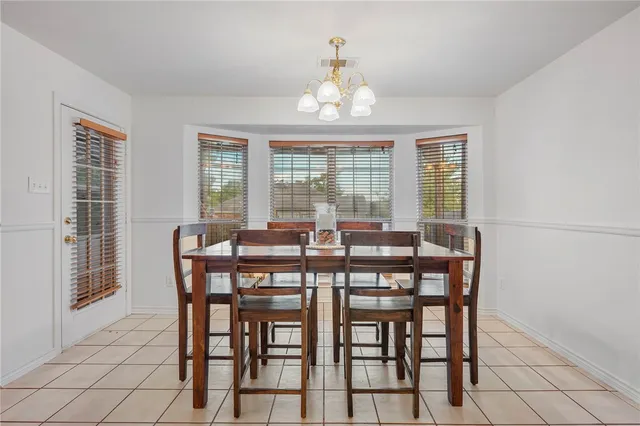 a view of a dining room with furniture a chandelier and wooden floor