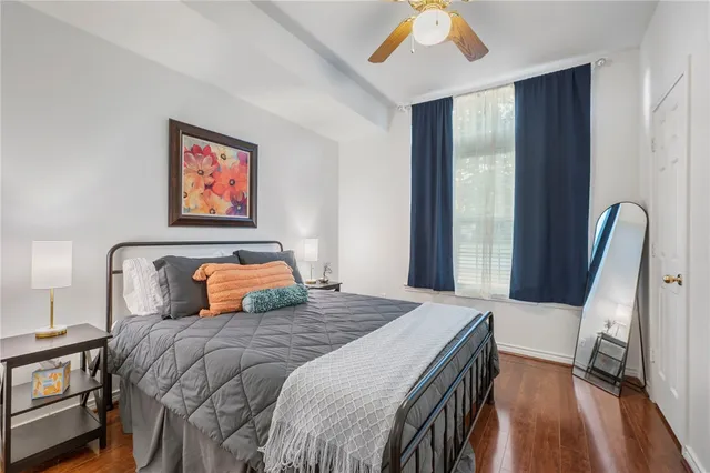 a bedroom with a bed and a large mirror next to a window