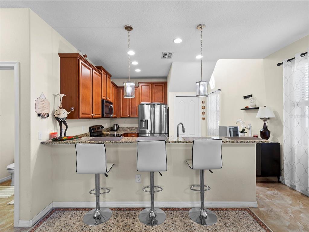 1716 Hadden Hall Place Trinity, FL 34655 - Photo 12 of 75 a kitchen with refrigerator and chairs
