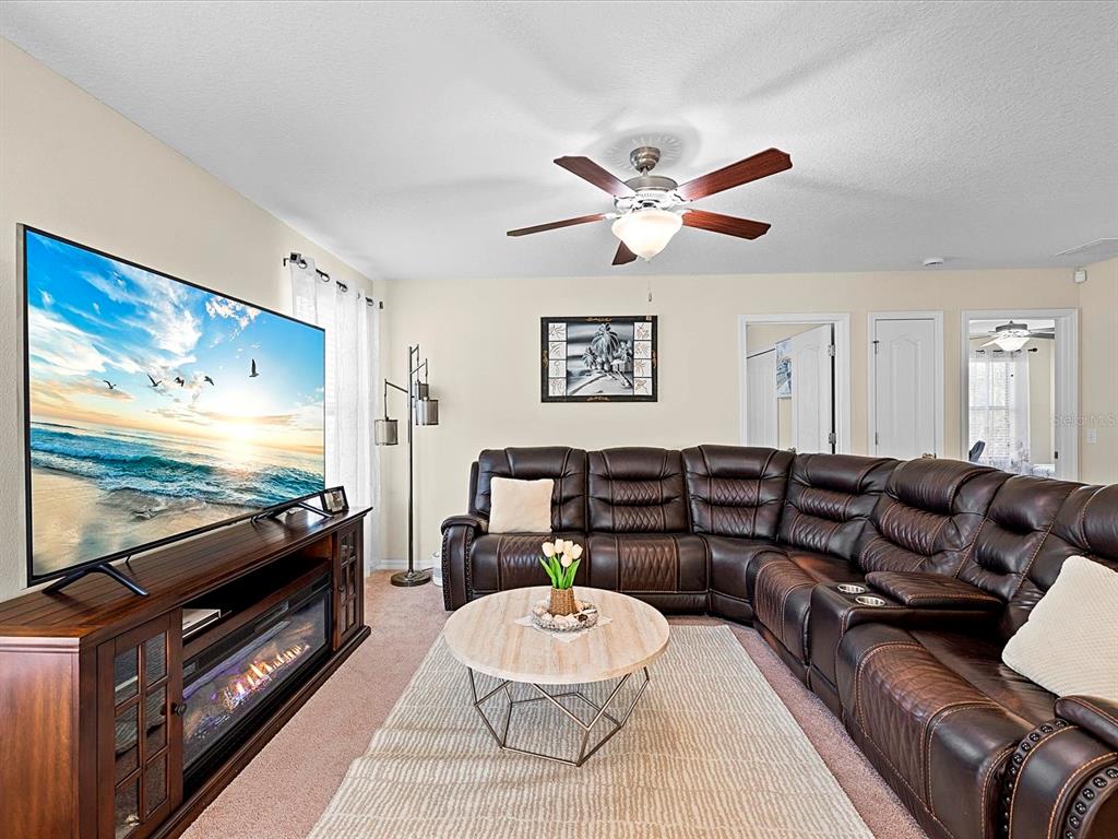 1716 Hadden Hall Place Trinity, FL 34655 - Photo 25 of 75 a living room with furniture a flat screen tv and a dining table
