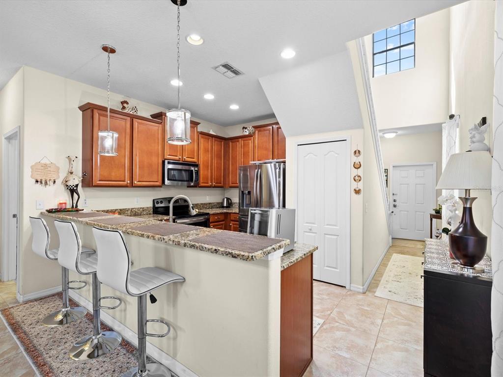 1716 Hadden Hall Place Trinity, FL 34655 - Photo 10 of 75 a kitchen with stainless steel appliances granite countertop a refrigerator a sink a stove and a cabinets
