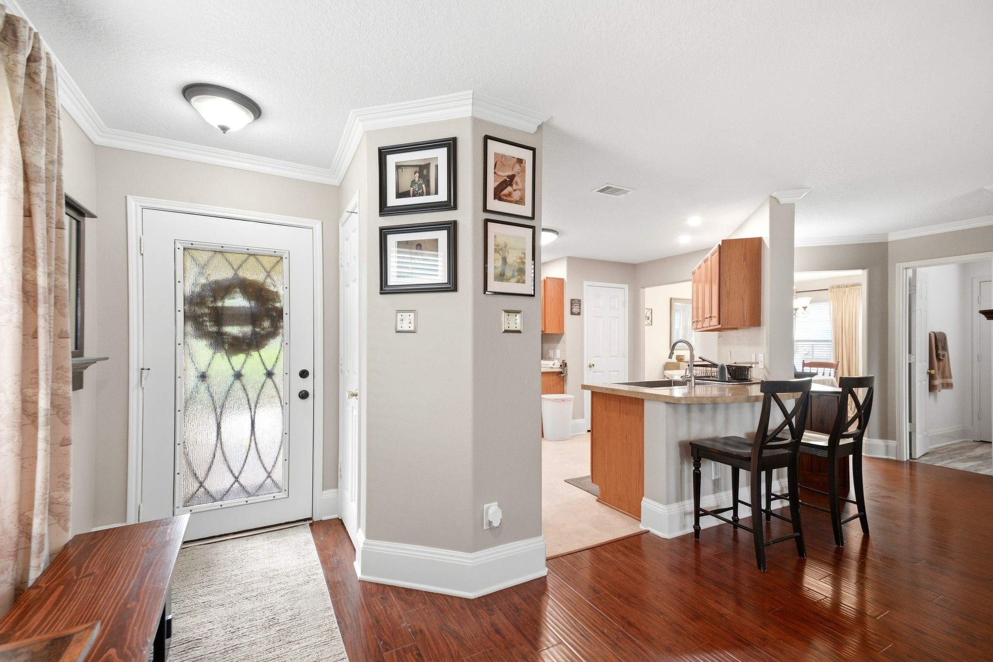 16954 Tableland Trail Conroe, TX 77385 - Photo 6 of 33 Inviting entry opens to beautiful wood-look flooring, crown molding, and a functional open-concept design with a convenient breakfast bar overlooking the main living areas.