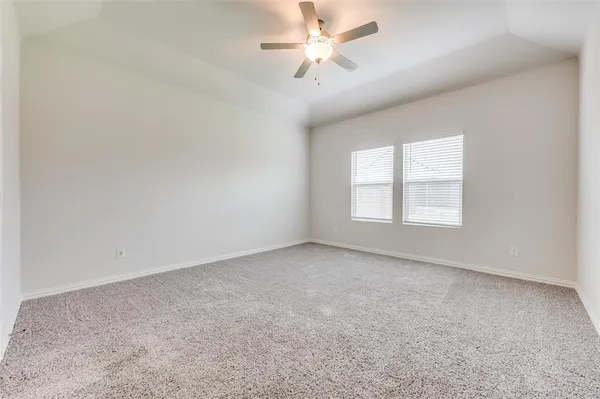 an empty room with a window and a ceiling fan