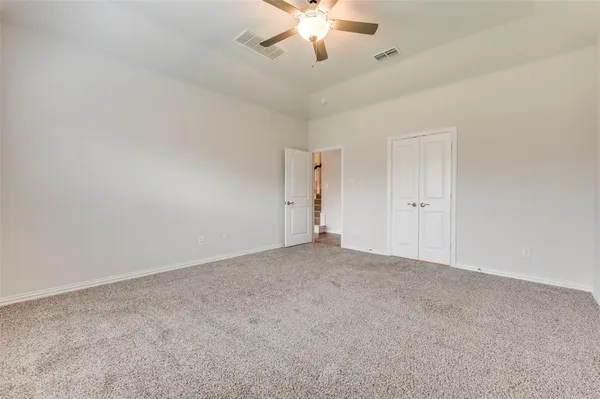 a view of an empty room with a chandelier fan