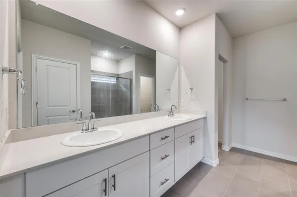 a bathroom with a double vanity sink and mirror