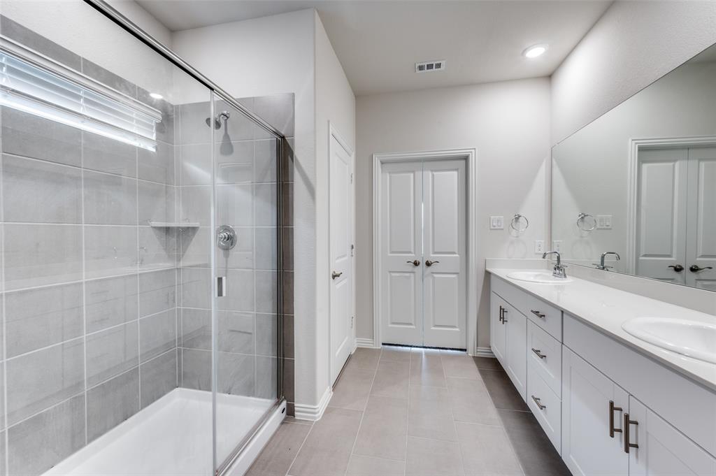 3308 Kingsdown Drive Denton, TX 76207 - Photo 16 of 25 a spacious bathroom with a double vanity sink a mirror and a bathtub