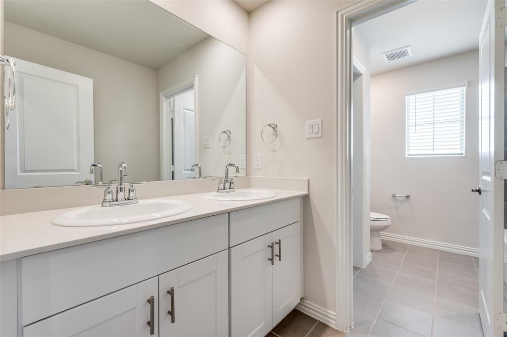 3308 Kingsdown Drive Denton, TX 76207 - Photo 22 of 25 a bathroom with a double vanity sink toilet and a mirror
