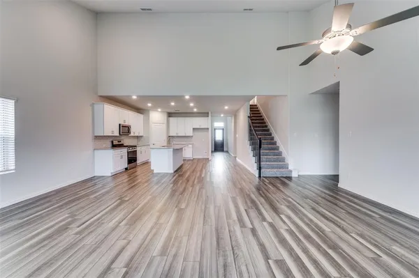 a view of a living room with wooden floor and ceiling fan