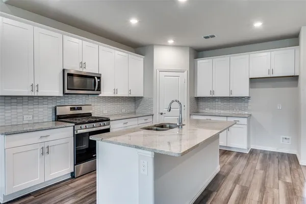 a kitchen with appliances a sink and cabinets