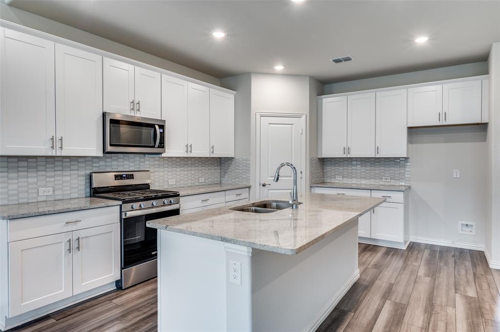 3308 Kingsdown Drive Denton, TX 76207 - Photo 8 of 25 a kitchen with appliances a sink and cabinets