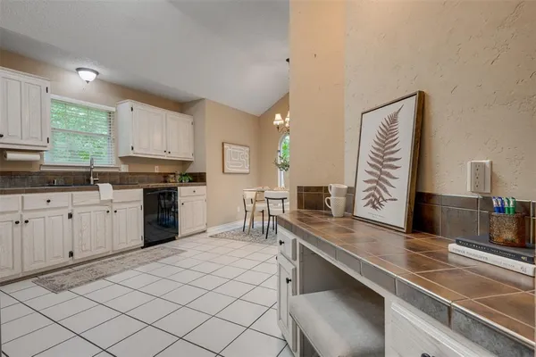 a kitchen with white cabinets and refrigerator