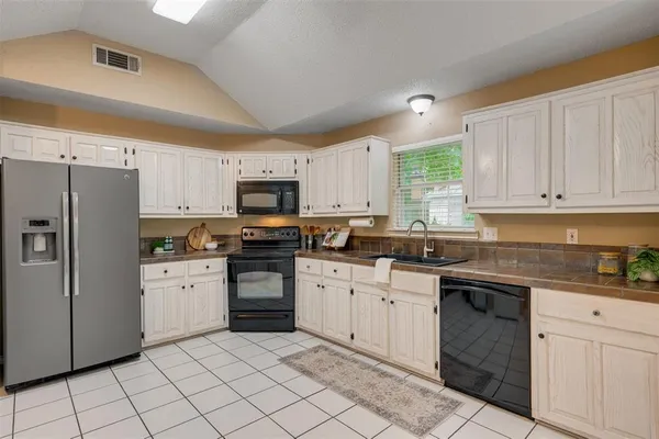 a kitchen with white cabinets and appliances