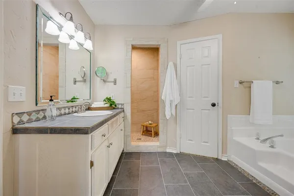 a bathroom with a bathtub a sink and a shower