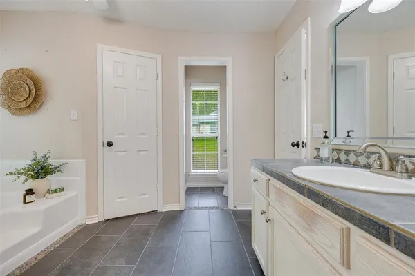 a bathroom with a bathtub a sink and a window