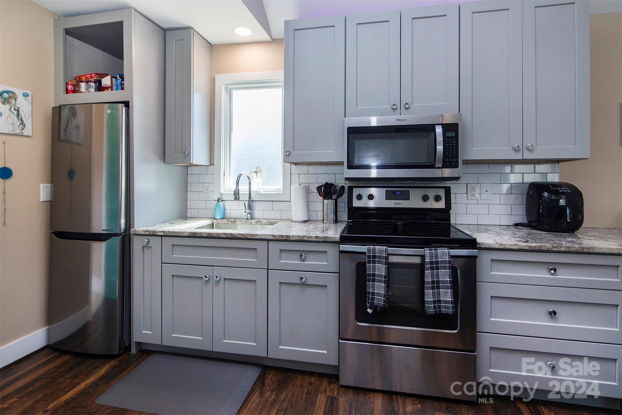3741 Woodleaf Road Charlotte, NC 28205 - Photo 21 of 31 a kitchen with stainless steel appliances granite countertop a refrigerator stove and white cabinets