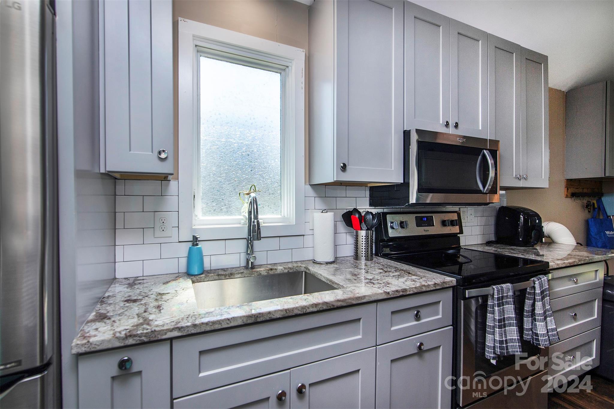 3741 Woodleaf Road Charlotte, NC 28205 - Photo 22 of 31 a kitchen with granite countertop a sink a stove and cabinets