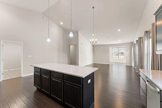 a kitchen with kitchen island a sink appliances and wooden floor