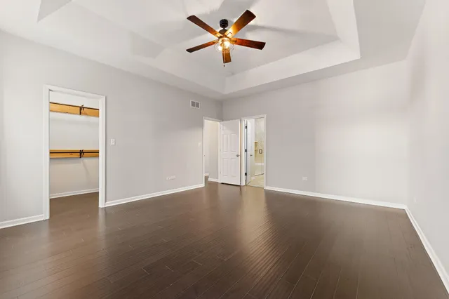 a view of an empty room with window and a ceiling fan